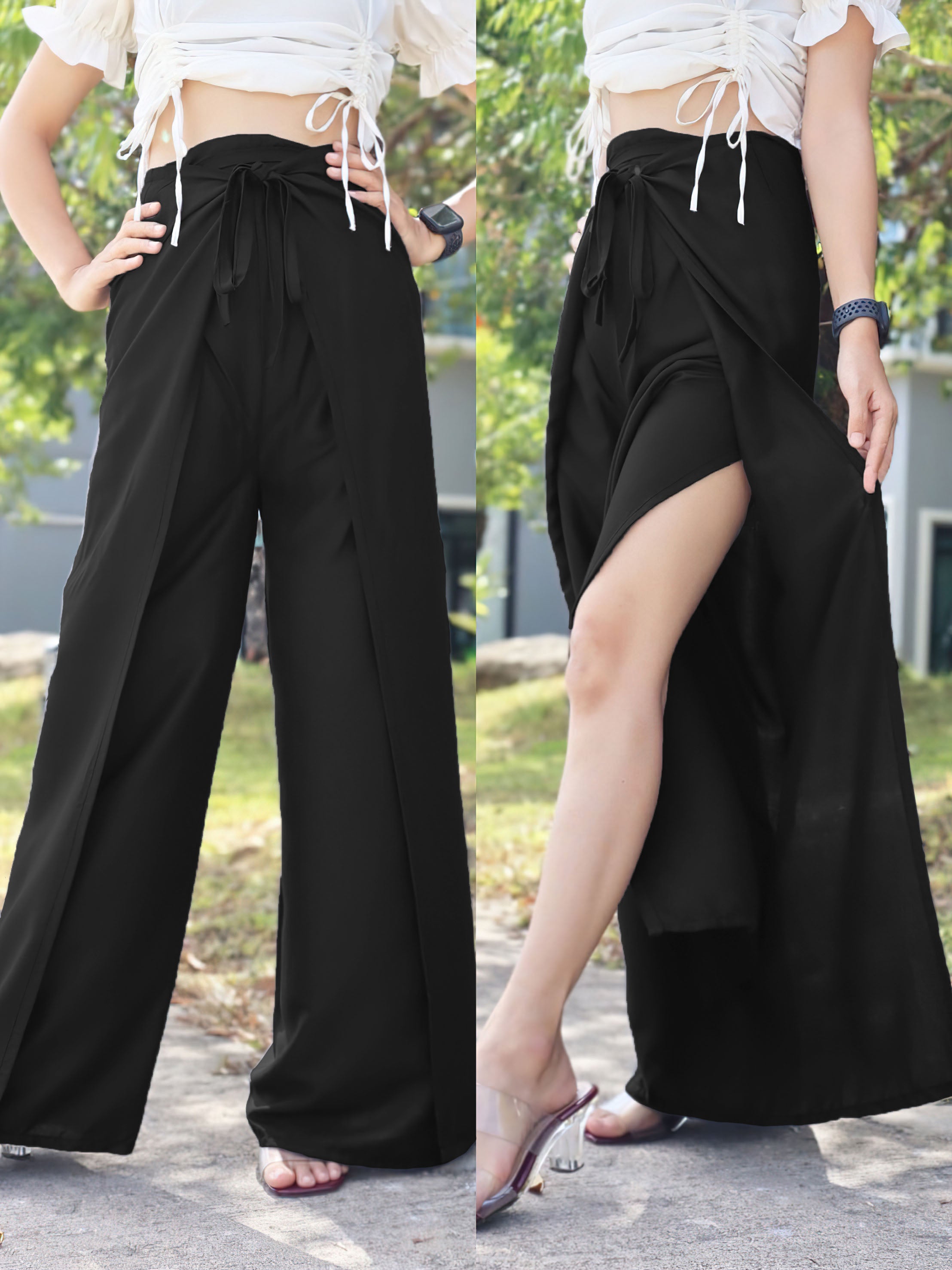 Black boho wrap pants with adjustable waist tie and high side slit, paired with a white lace-up crop top, showcased in an outdoor setting with natural light.