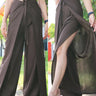 Boho brown wrap pants, paired with a white fringed crop top and clear strapped heels, showcased in a natural outdoor setting.
