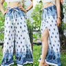 Chic boho wrap pants with a white and blue pattern, showcasing the unique wrap design in a natural outdoor setting.