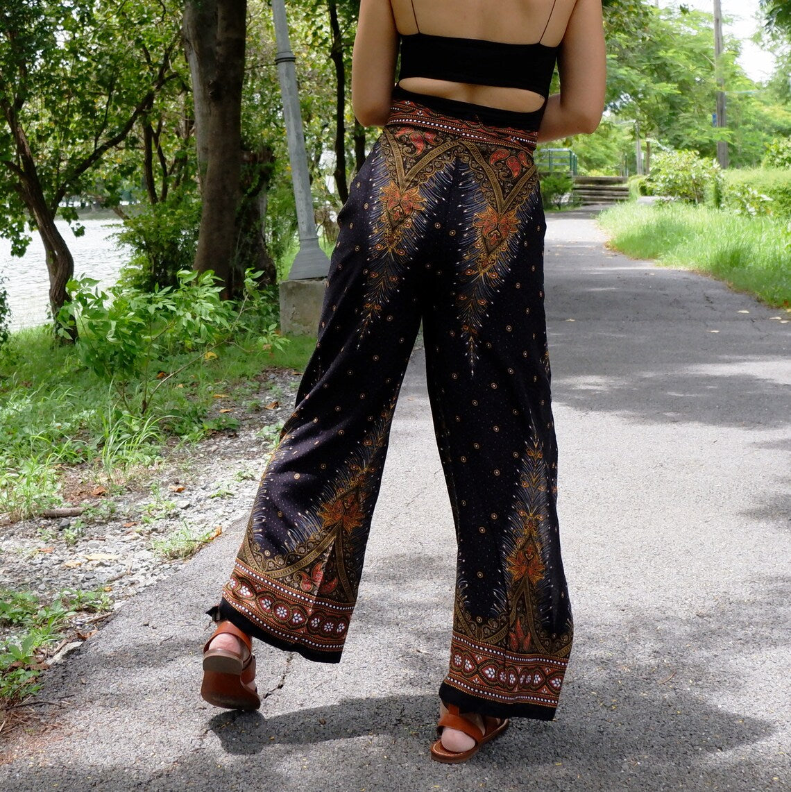 Fashion-forward black boho feather print wrap pants paired with a sleek black top, perfect for a stylish outdoor ensemble.