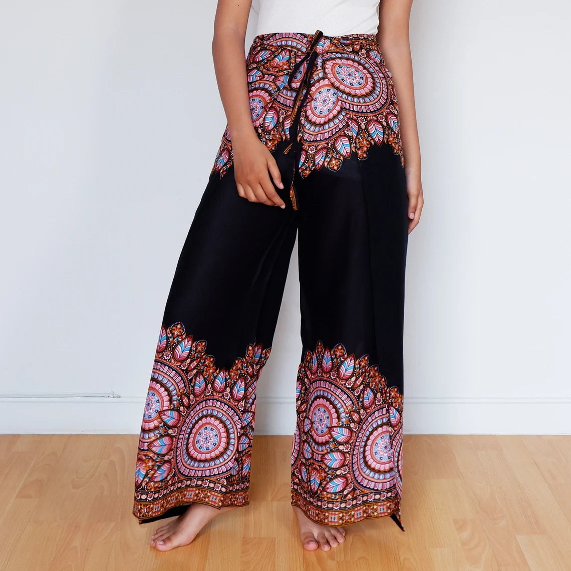 Woman in black wrap pants with vibrant mandala border, perfect for bold boho looks.