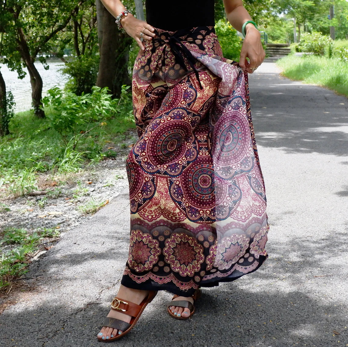Flowing deep purple wrap pants with mandala motifs, styled outdoors for a festival look.