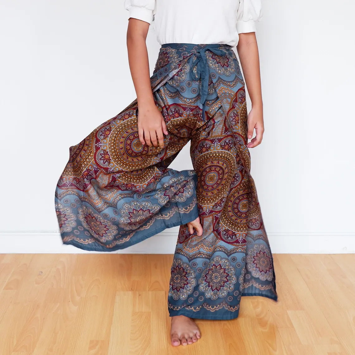 Muted blue mandala wrap pants mid-motion, capturing the flow of boho festival fashion.