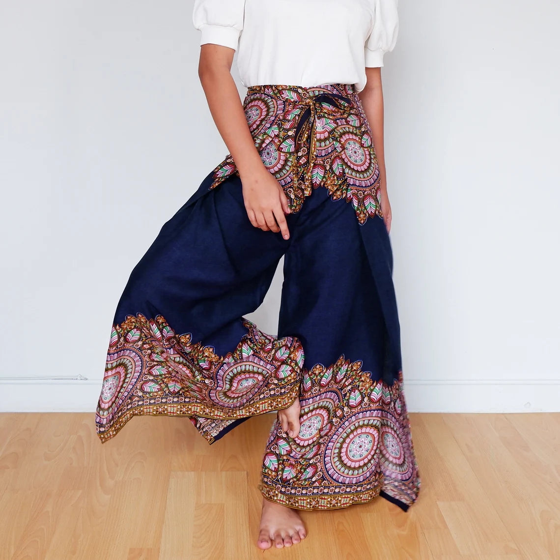 Navy boho wrap pants in motion with detailed mandala pattern on waistband and hem.