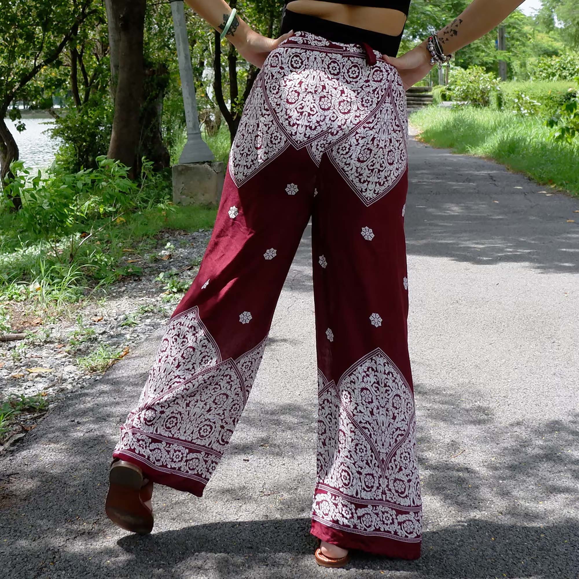 Chic Burgundy Red Boho Wrap Pants with White Floral Print Outdoors.
