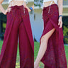 Chic maroon boho wrap pants with peacock feather print, paired with a white lace-up crop top for a trendy look.
