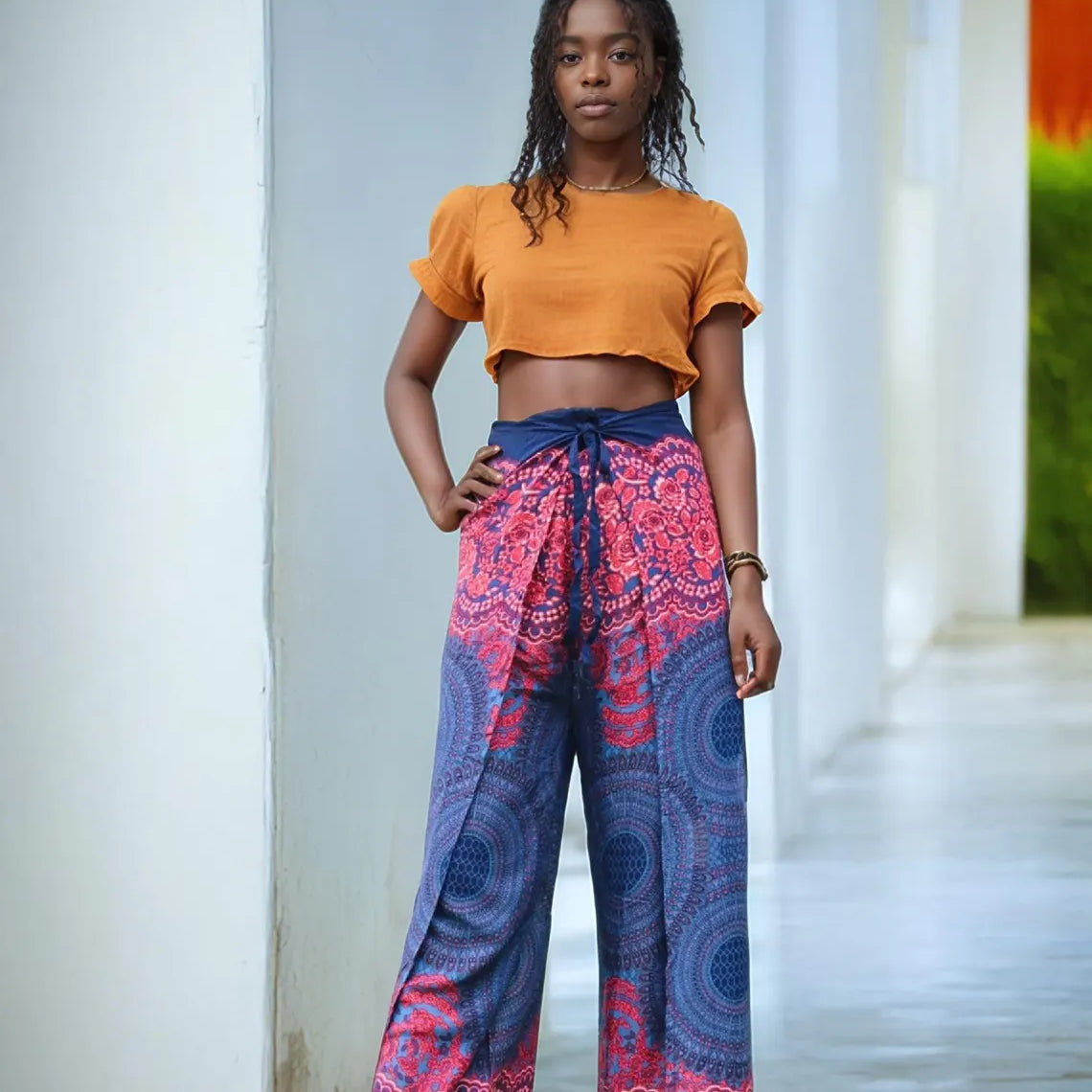 Boho wide-leg wrap pants in red and blue mandala print – festival-ready fashion modeled indoors