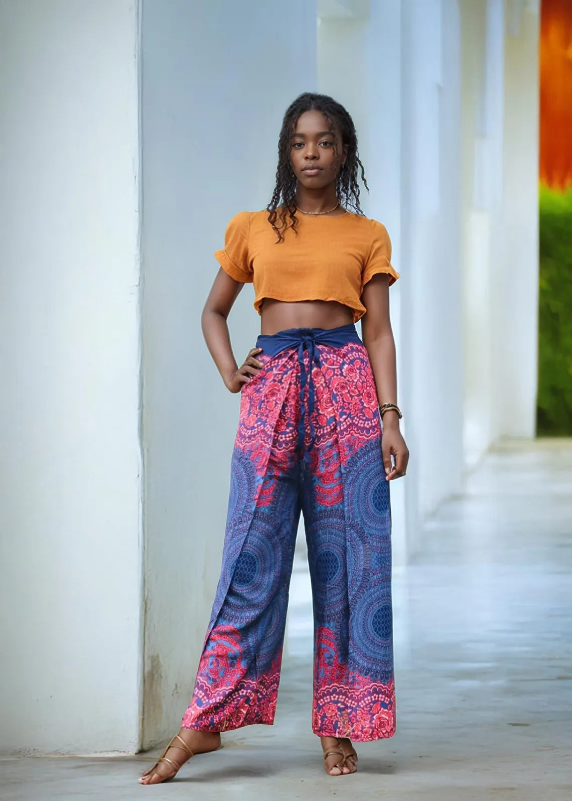 Boho wide-leg wrap pants in red and blue mandala print – festival-ready fashion modeled indoors