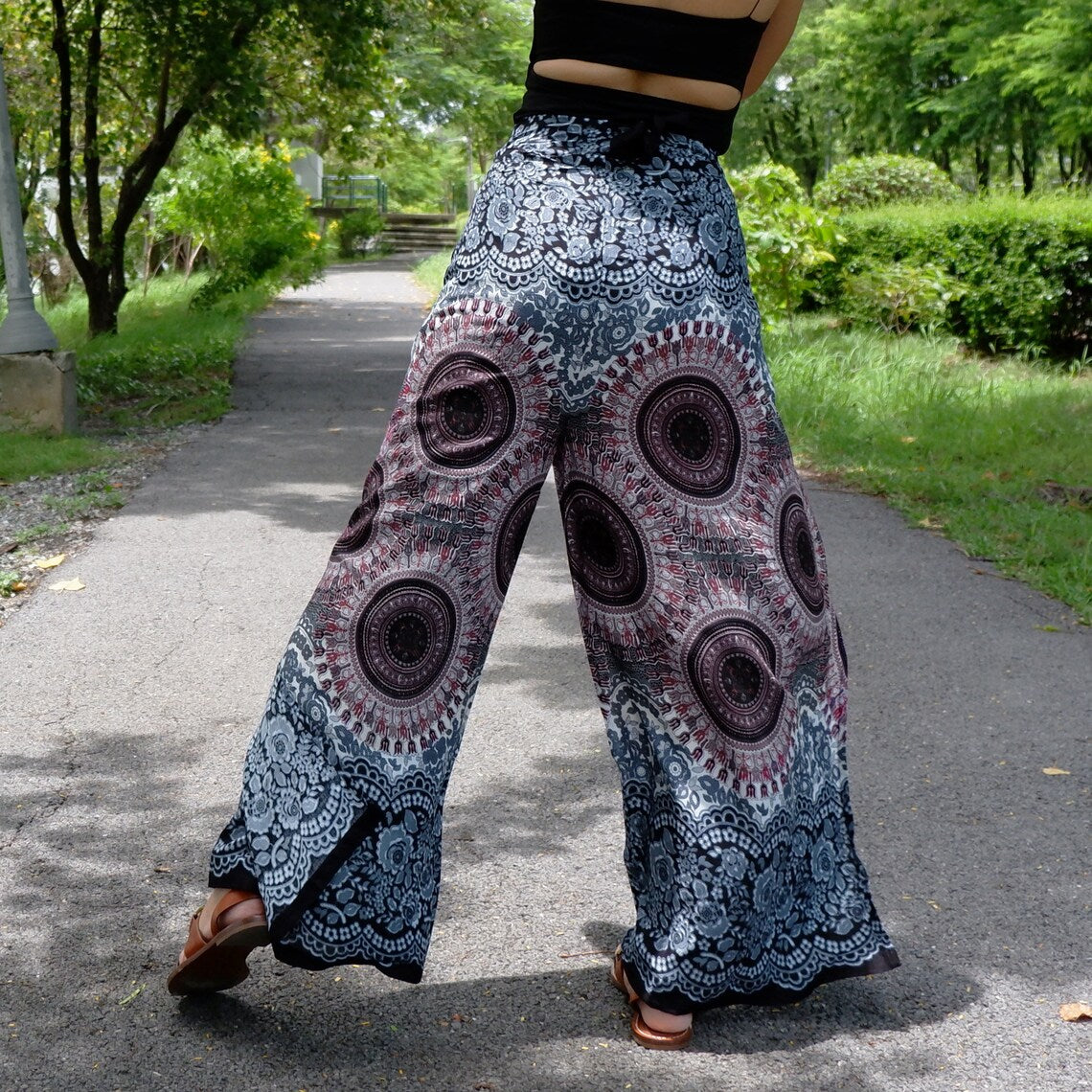 Wide-leg wrap pants in gray and black with mandala and lace-look floral border, viewed from behind
