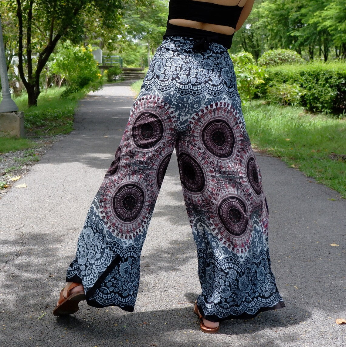 Wide-leg wrap pants in gray and black with mandala and lace-look floral border, viewed from behind
