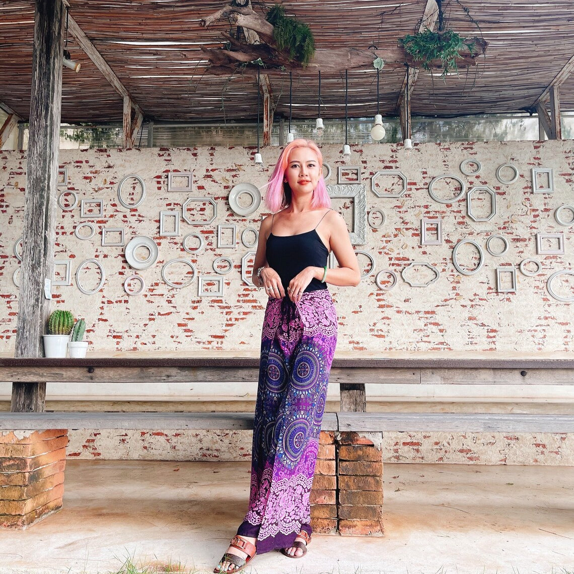 Purple and pink mandala wrap pants styled with black tank top, festival-ready boho fashion
