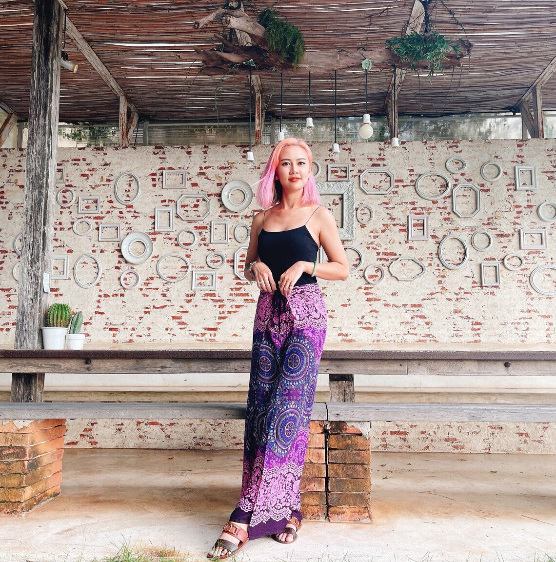 Purple and pink mandala wrap pants styled with black tank top, festival-ready boho fashion
