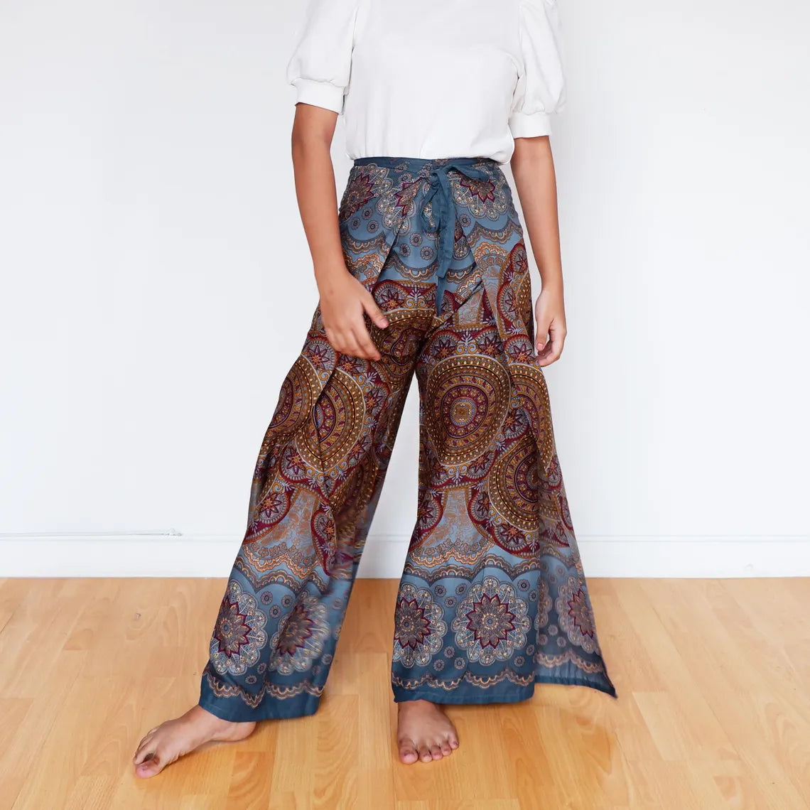 Woman in muted blue mandala wrap pants with earthy boho patterns.