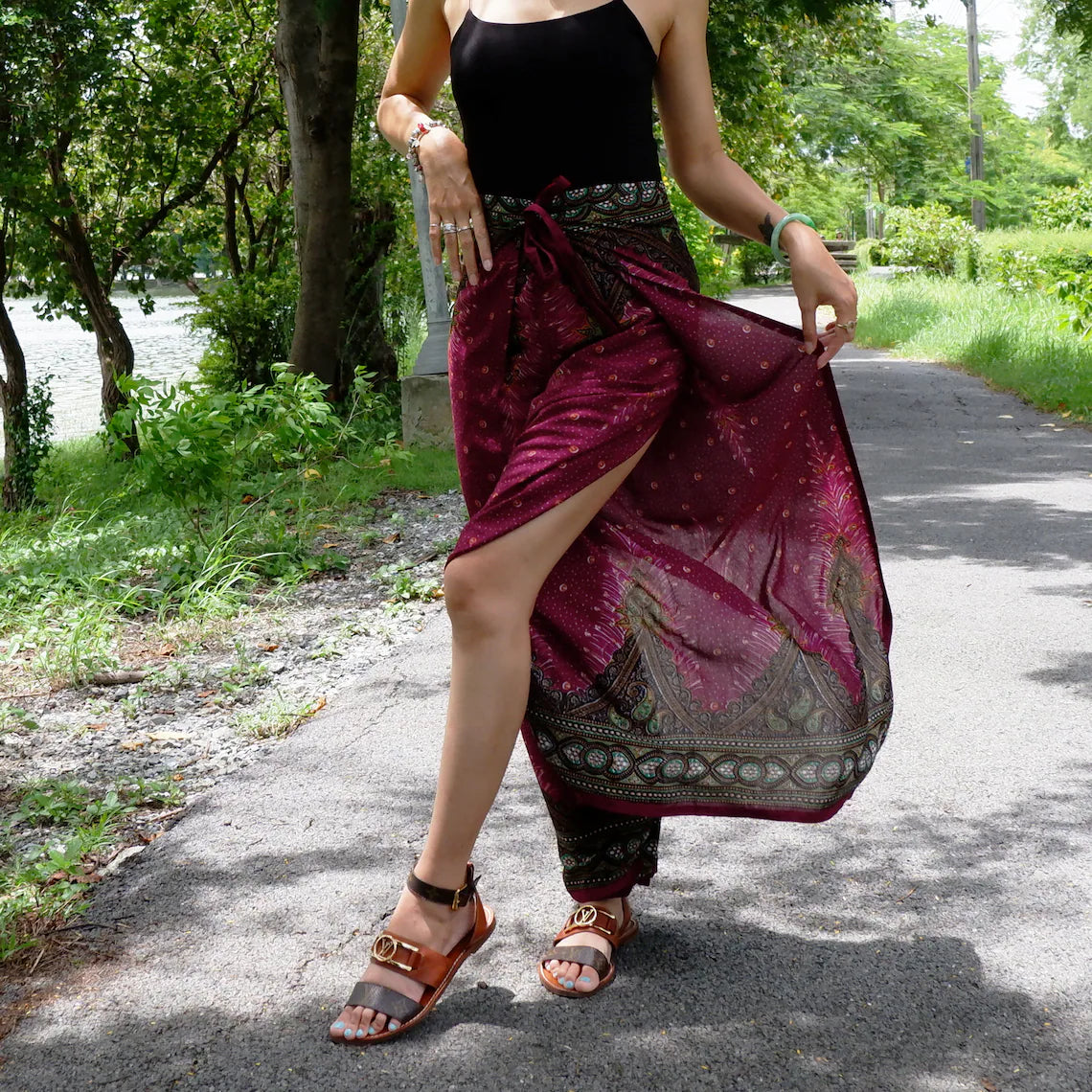 Trendy red maroon boho feather print wrap pants paired with a sleek black top, ideal for a stylish outdoor look.