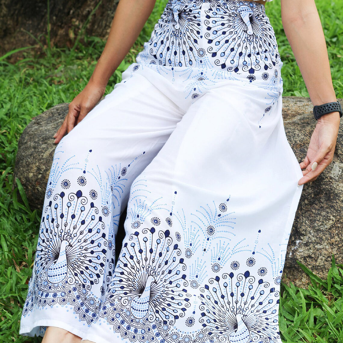Trendsetting white boho wrap pants adorned with blue peacock print, perfect for a serene yet stylish look.